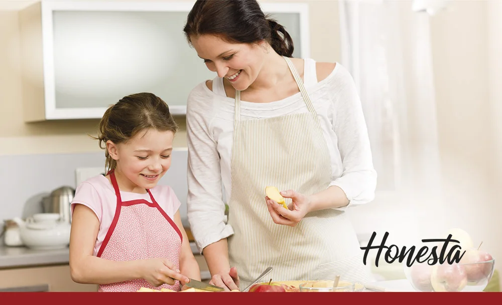 Madre e hija preparando fruta en la cocina